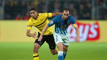 Godín lucha un balón contra un jugador del Borussia Dortmund.