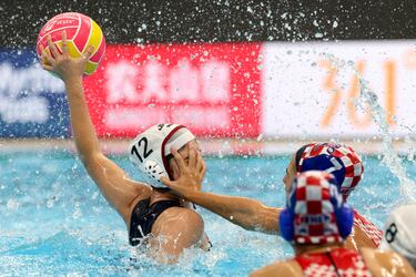 Una jugadora de Croacia agarra la cara de una rival japonesa en su intento de interceptar el balón en un lance de su partido de waterpolo femenino disputado en los Mundiales Acuáticos que se están desarrollando en Singapur. La arlequinada se equivocó de esférico, una confusión que seguro que no fue del todo agradable para la jugadora asiática. 
