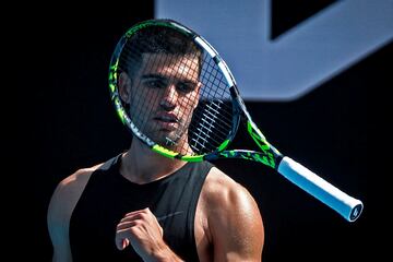 Carlos Alcaraz, visto a travs del cordaje de su raqueta mientras juega con ella en su entrenamiento junto con Taylor Fritz. El murciano de 21 a?os, que debutar en Melbourne Park, ultima los preparativos para convertirse en el noveno hombre en la historia que gana al menos una vez todos los Grand Slam individuales.