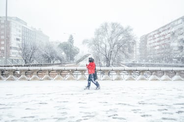 Un par de peatones caminan por la nieve de camino a la estación de Chamartín.