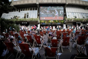 Espectadores ven el partido de tenis en una pantalla gigante en los aledaños del estadio.