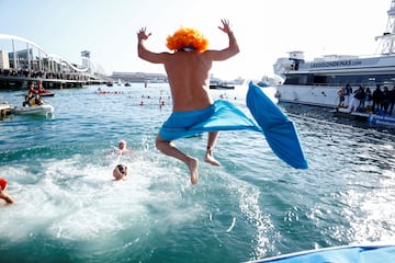 Un hombre vestido de sirena salta al mar.