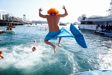 Un hombre vestido de sirena salta al mar.