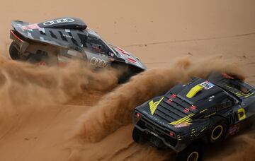 El piloto español de Audi (a la izquierda) Carlos Sainz y el copiloto español Lucas Cruz pasan junto al piloto francés Simon Vitse y el copiloto francés Frederic Lefebvre durante la etapa de hoy. 