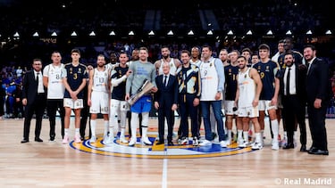 Luka Doncic con la r¨¦plica de la Euroliga que conquista en 2018 con el Real Madrid. En la imagen, con el presidente del club, Florentino P¨¦rez, la actual plantilla y jugadores que conquistaron el trofeo con el esloveno tras ganar al Fenerbahce.