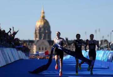 Comentario atribuido a Paul Gilham, director global de deportes en Getty Images 
Esta cautivadora fotografía, tomada por el talentoso Al Bello, fotógrafo de Getty Images, encapsula la esencia de la determinación atlética y el espíritu competitivo. La imagen presenta a tres atletas en medio de un triatlón, cada uno empujando sus límites mientras corren hacia la línea de meta. El atleta líder, capturado en pleno paso, irradia una sensación de urgencia y concentración, personificando la búsqueda implacable de la victoria.
El fondo desenfocado, lleno de espectadores animando, añade a la atmósfera dinámica, destacando el apoyo y la emoción que impulsan a estos atletas. La distintiva estructura de cúpula dorada en la distancia no solo proporciona un telón de fondo único, sino que también sitúa este evento en una ciudad conocida por sus icónicos monumentos.
Esta fotografía, capturada hábilmente a través del lente de Al Bello, sirve como un poderoso recordatorio de la dedicación y el arduo trabajo que definen a los Juegos Olímpicos. 
