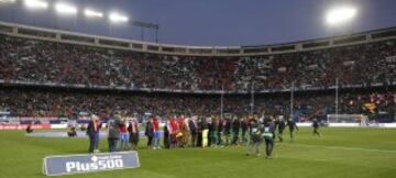 Saltan al césped los jugadores del Atlético y Betis, y los once del Atlético lo hacen de la mano de los once socios rojiblancos más antiguos
