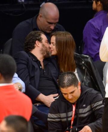 El director de cine Brett Ratner y la modelo Marcelle Braga se besan en el Staples Center.