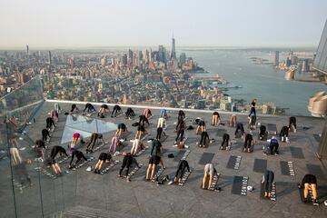 Un grupo de personas hace yoga en la azotea de un edificio de Manhattan (Nueva York). Como ocurre con muchos tipos de ejercicios al aire libre, esta práctica cogió gran demanda durante la pandemia del coronavirus, y no se ha pasado de moda, sino más bien al contrario: hay semanas de lista de espera para asistir a las clases.