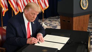 US President Donald Trump signs executive orders extending coronavirus economic relief, during a news conference in Bedminster, New Jersey, on August 8, 2020. (Photo by JIM WATSON / AFP)