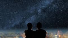 Imagen de una pareja contemplando una noche muy estrellada.