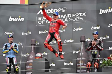 Marc Márquez ganador del Gran Premio de Austria, sube al podio mientras celebra junto al piloto español Fermín Aldeguer (izq.), del equipo BK8 Gresini Racing MotoGP, segundo clasificado, y al piloto italiano Marco Bezzecchi, del equipo Aprilia Racing, tercero.