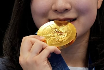 Hyojin Ban of South Korea bites her gold medal after her 10m Air Rifle Women's Victory Ceremony.