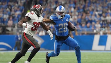 DETROIT, MICHIGAN - JANUARY 21: Jahmyr Gibbs #26 of the Detroit Lions is pursued by Jamel Dean #35 of the Tampa Bay Buccaneers during the third quarter of the NFC Divisional Playoff game at Ford Field on January 21, 2024 in Detroit, Michigan. Nic Antaya/Getty Images/AFP (Photo by Nic Antaya / GETTY IMAGES NORTH AMERICA / Getty Images via AFP)
