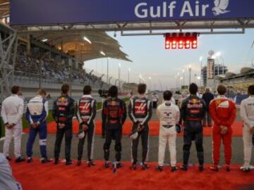 Los pilotos escuchan el himno nacional antes de la carrera.