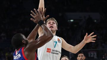 FIJ02 ESTAMBUL (TURQUÍA) 12/10/2017.- El base esloveno del Real Madrid Luka Doncic (c) trata de anotar el pívot estadounidense del Anadolu Efes Bryant Dunston (i) durante un encuentro de Euroliga disputado en Estambul, Turquía, hoy, 12 de octubre de 2017. EFE/SEDAT SUNA