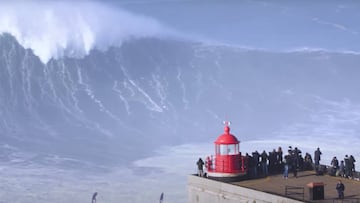 Un surfista en una ola gigante en Nazar&eacute; (Portugal) con el faro en primer plano, durante el Nazar&eacute; Tow Surfing Challenge. 