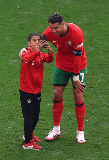 Cristiano Ronaldo de Portugal se toma una selfie con un joven.