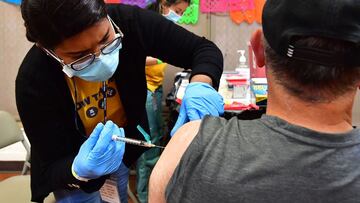 Registered Nurse Mariam Salaam administers the Pfizer booster shot at a Covid vaccination and testing site decorated for Cinco de Mayo at Ted Watkins Park in Los Angeles on May 5, 2022. - Covid cases in Los Angeles County have topped 3,000 for the first time since mid-February with cases up nearly 300 percent in the past month, sparking concern of a potential "sixth wave" pandemic in the US. (Photo by Frederic J. BROWN / AFP)