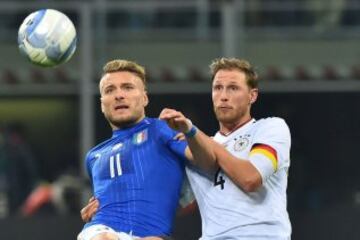 Italy's forward Ciro Immobile (L) fights for the ball with Germany's defender Benedikt Hoewedes  during the International friendly football match Italy vs Germany on November 15, 2016 at the 'San Siro Stadium' in Milan.  / AFP PHOTO / GIUSEPPE CACACE