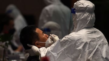 A medical worker takes a test sample for the Covid-19 virus from a South Korean tourist on Phu Quoc island on November 20, 2021, as the island welcomes its first international tourists to arrive after a Covid-19 coronavirus vaccine passport scheme kicked off this month in Vietnam. (Photo by Nhac NGUYEN / AFP)