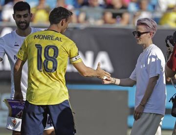 Women&#039;s U.S. Soccer team star Megan Rapinoe, right, greets Arsenal&#039;s Nacho Monreal (18) at an International Champions Cup soccer match between Arsenal and Fiorentina in Charlotte, N.C., Saturday, July 20, 2019. (AP Photo/Chuck Burton)