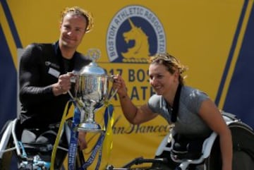 El ganador de la edición en silla de ruedas masculino Marcel Hug y la ganadora femenina Manuela Schar, posan con el trofeo.