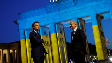 Germany&#039;s Chancellor Olaf Scholz and France&#039;s President Emmanuel Macron visit the Brandenburg Gate, while it is illuminated in the colours of the Ukrainian flag, amid Russia&#039;s attack on Ukraine, in Berlin, Germany May 9, 2022. REUTERS/Miche