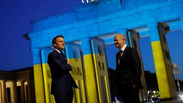 Germany&#039;s Chancellor Olaf Scholz and France&#039;s President Emmanuel Macron visit the Brandenburg Gate, while it is illuminated in the colours of the Ukrainian flag, amid Russia&#039;s attack on Ukraine, in Berlin, Germany May 9, 2022. REUTERS/Miche