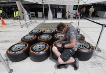 Uno de los mecánicos de Mercedes marcando los neumáticos frente del garaje del equipo