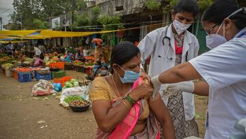 A health worker inoculates a woman with a dose of the Covishield vaccine against the Covid-19 coronavirus during a vaccination drive at a vegetable market in Hyderabad on June 24, 2021. (Photo by NOAH SEELAM / AFP)