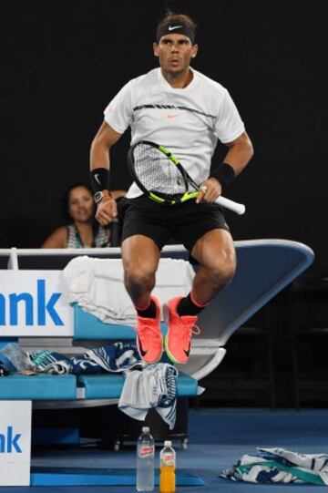 Rafael Nadal calienta mientras Roger Federer recibe asistencia médica en el vestuario.