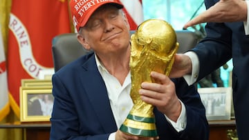 President Donald Trump holds the FIFA World Cup Winners Trophy during an announcement in the Oval Office of the White House, Friday, Aug. 22, 2025, in Washington. (AP Photo/Jacquelyn Martin)