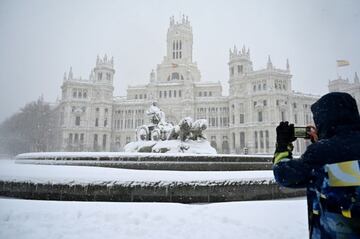 Una persona fotografía a la estatua de Cibeles de Madrid. 