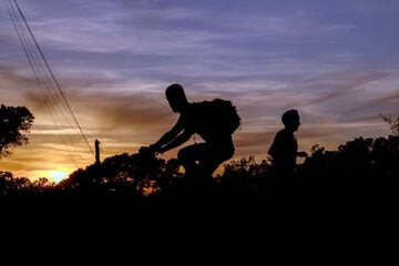 Un ciclista y un corredor en la carretera del Tibiado en Barcelona, a última hora de este sábado, la primera jornada desde que se decretara el estado de alarma en la que las personas adultas salen a la calle a pasear y hacer deporte individual en franjas horarias distintas. EFE/Alberto Estévez