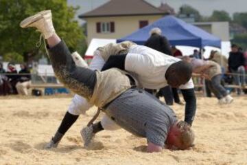 Un oponente levanta al luchador senegalés Dieylani Pouye durante una pelea, en un torneo de clasificación en Romont. Pouye intentará clasificarse para el evento de lucha libre de Swiss Alpine Festival Federal de este año, el deporte más antiguo de Suiza