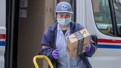 A US Postal Service carrier wears a mask and gloves in Washington. 