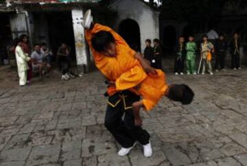 Dos niños practican durante una sesión de entrenamiento de artes marciales "Wushu" a primera hora de la mañana en Katmandú (Nepal) hoy, miércoles 2 de octubre de 2013. Los expertos en artes marciales Dhan Kumar Ghising y Lessa Shrestha Ghising han organizado de manera conjunta sesiones de entrenamiento para 20 niños de entre cinco y seis años en la ciudad de Katmandú. La pareja de profesores se dedica a entrenar a niños para el arte marcial del wushu, un milenario deporte que hace parte de la herencia cultural china y que, tras una serie de ajustes reglamentarios busca de nuevo su posicionamiento global. El coste de estas clases es de 50 rupias (37 céntimos de euro) para las niñas y 100 rupias (74 céntimos de euro) para los niños.