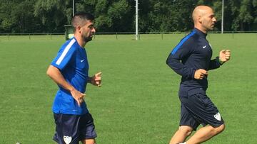 Michel Santos corriendo aparte con el preparador físico del Málaga, Hugo Camarero.