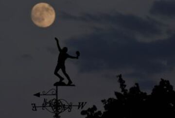 La luna se eleva por encima de la veleta en el Lawn Tennis y Croquet Club All England, que acoge el Campeonato de tenis de Wimbledon