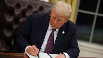 U.S. President Donald Trump signs documents as he issues executive orders and pardons for January 6 defendants in the Oval Office at the White House on Inauguration Day in Washington, U.S., January 20, 2025. REUTERS/Carlos Barria