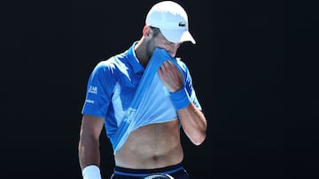 Serbia's Novak Djokovic wipes his face between games during his men's singles semifinal match against Germany's Alexander Zverev on day thirteen of the Australian Open tennis tournament in Melbourne on January 24, 2025. (Photo by Martin KEEP / AFP) / -- IMAGE RESTRICTED TO EDITORIAL USE - STRICTLY NO COMMERCIAL USE --