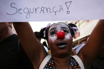 A protester stands holding a sign calling for public security along the Olympic torch route ahead of the Rio 2016 Olympic Games on August 2, 2016 in Sao Goncalo, Rio de Janeiro state, Brazil. A group of around 50 protesters, calling for funds for health a