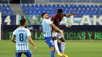 Armando Sadiku disputa un balón con Lomotey ante la mirada de Adrián durante el Málaga-Extremadura.