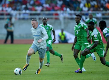 Wayne Rooney (L) runs with the ball during a SportsPesa Super Cup final football match against Gor Mahia in Dar-es-Salaam.