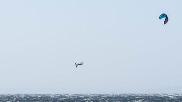 Un kitesurfista vuela alto en la playa de Valdevaqueros (Tarifa), Cádiz, durante la celebración del campeonato de España de Big Air disputado el domingo 24 de septiembre, con vientos de más de 30 nudos. En la foto hay público mirando desde la playa.