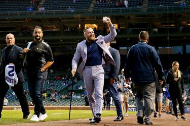 Conor McGregor saluda a los aficionados que presencian el partido de la liga estadounidense de béisbol (Major League Baseball, MLB) y que enfrenta a los Chicago Cubs con los Minnesota Twins, encuentro en el que el luchador de UFC realiza el saque de honor, con tan poco tino que demuestra que este deporte no es lo suyo.
