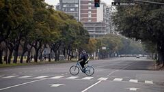 A man crosses an avenue on his bicycle in Buenos Aires on July 18, 2020 a day after Argentina&#039;s government announced it was relaxing coronavirus containment measures in the capital to fight the COVID-19 pandemic. - From Monday, non-essential businesses, industry and certain professional activities can restart and citizens will also be allowed to go outside for sport and to visit places of worship. (Photo by Alejandro PAGNI / AFP)