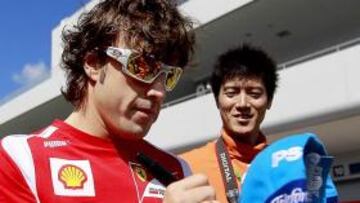 <b>MUY SOLICITADO. </b>Alonso firma una gorra a uno de los aficionados que se acercaron a Suzuka.
