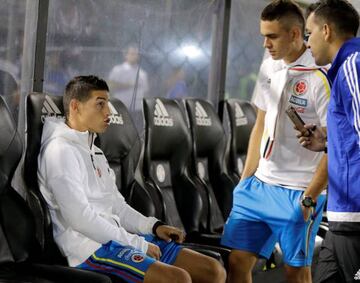 James Rodriguez (L) speaks to members of his team before the soccer match against Paraguay.